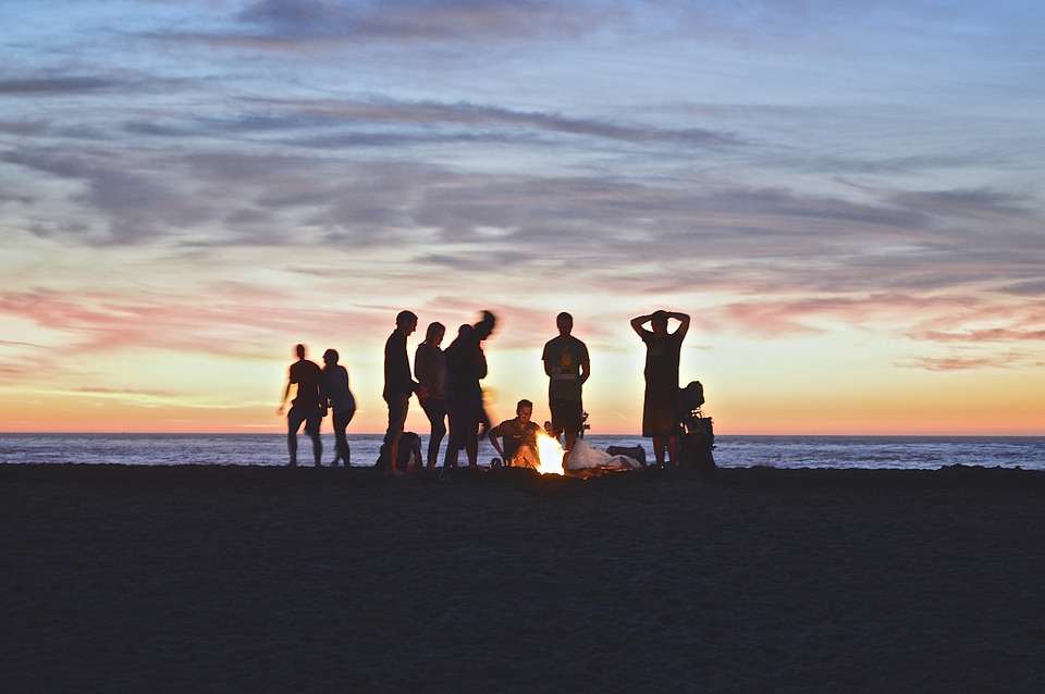 People around a campfire at a beach.