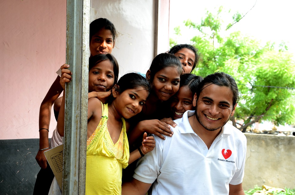Picture of kids in India participating with a volunteer in a service for their community.