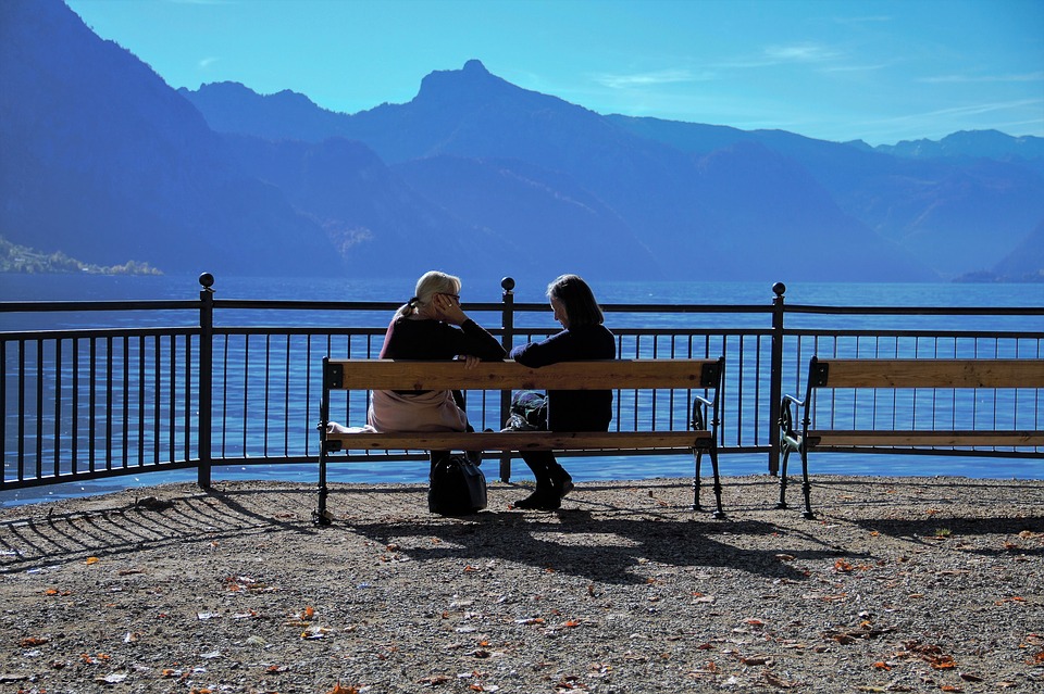Two women having a conversation on a bench.